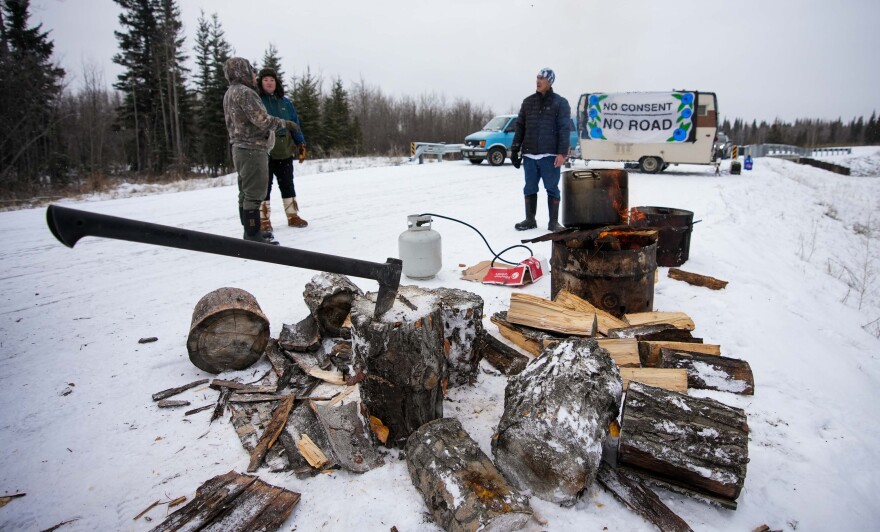 Blackade activists say more than two dozen members of the community stopped by to offer help and support for the protest. From left, Marcus Titus, Tara Colleen and Nathan, who didn't give his last name, stopped by Tuesday to split some wood and start a fire to cook up a big pot of moose stew.