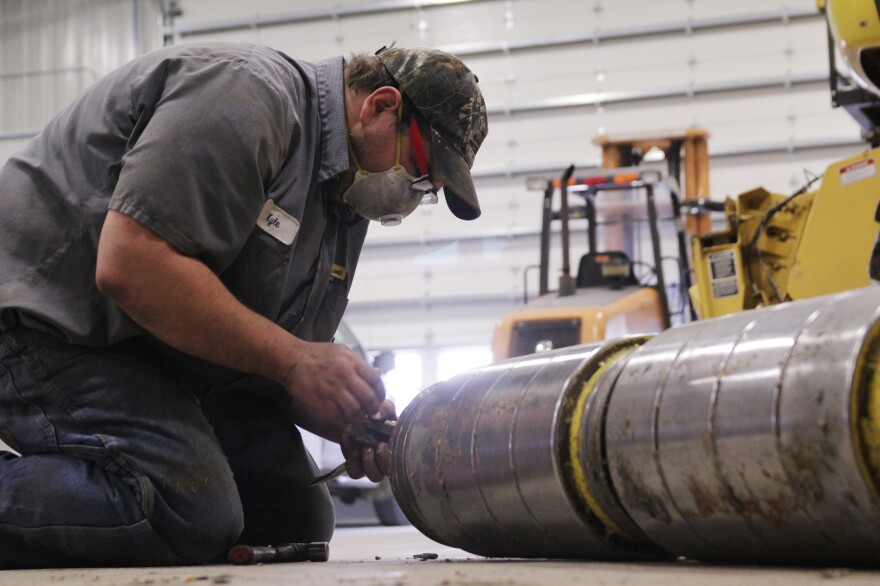 Kyle Garman, a technician at the the New Holland dealership in East Havana, Ill., takes apart the feeder head on a large combine. Owner Frank Hofreiter says farm customers are opting to repair old equipment rather than buy new.