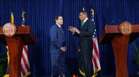 Two male political leaders face each other on a stage during joint press conference
