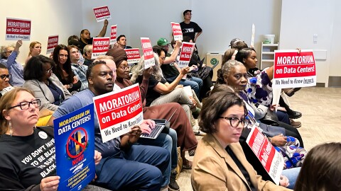 People hoisted pro-moratorium signs while Charlotte City Council debated holding a public hearing during
