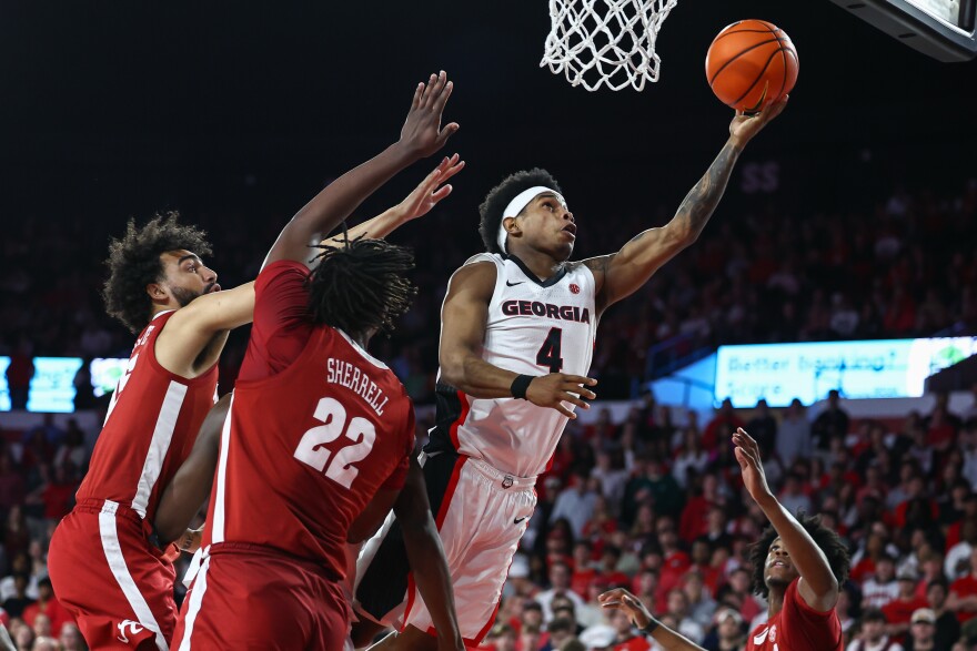Georgia guard Marcus Millender (4) shoots against Alabama guard Houston Mallette, left, and forward Aiden Sherrell (22) during the first half of an NCAA college basketball game, Tuesday, March. 3, 2026, in Athens, Ga. (AP Photo/Colin Hubbard)