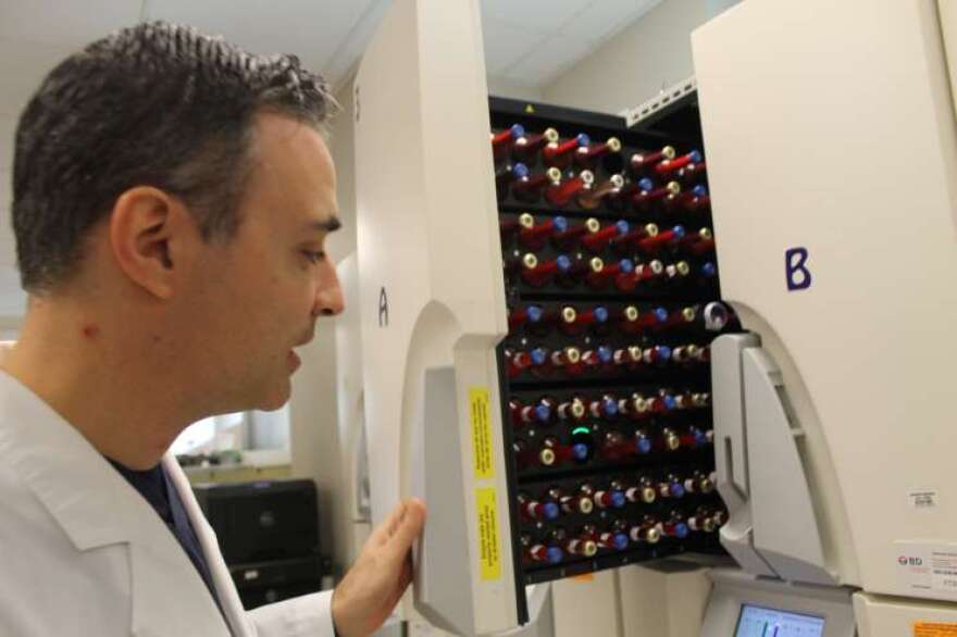 Dr. Federico Laham shows an automatic incubator at an Orlando Health microbiology lab.