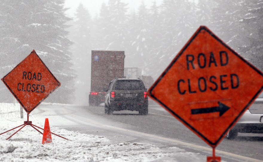 Trucks and other motorists make their way off of Interstate 90 where the pass ahead was closed Tuesday near North Bend, Wash. Snow has been falling steadily in various parts of western Washington since the weekend.