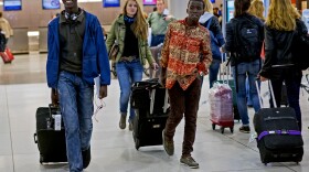 Thomas Nellon (left), 17, and his brother Johnson Nellon, 14, of Liberia smile at their mother in the arrivals area at John F. Kennedy International Airport in New York earlier this month. The brothers received a health screening upon arrival. The U.S. says it will step up screening measures for arrivals from Ebola-affected West African countries.
