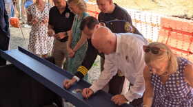 State and local officials sign a key support beam that will sit just above the basement of the new Williamsburg Police Department station building on Friday, July 19, 2024.