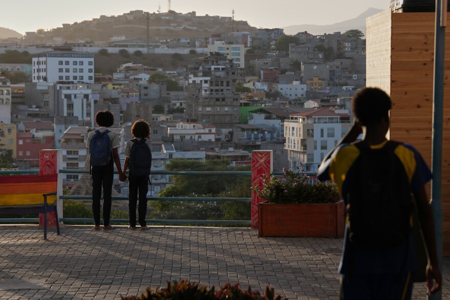 Two schoolgirls hold hands as they look towards the city in Praia, Cape Verde, Thursday, May 7, 2026. (AP Photo/Misper Apawu)