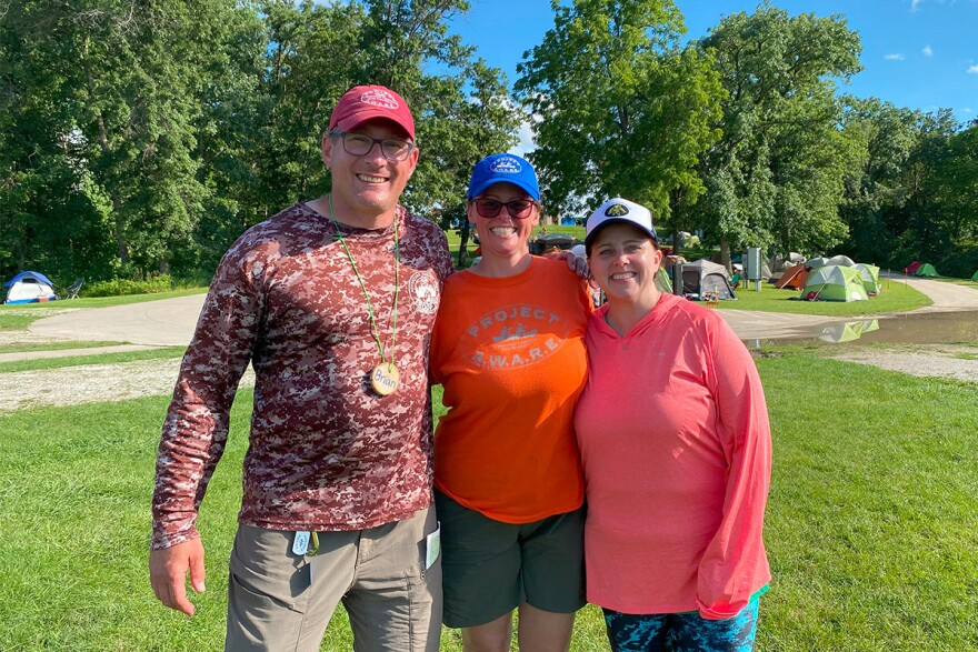 Brian Soenen, Liz Maas and Elizabeth Reetz pose at Lake Darling during the 2024 clean up week of Project AWARE.