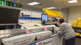 A Lane County Elections Office employee runs ballots through a signature verification machine, May 15, 2026.