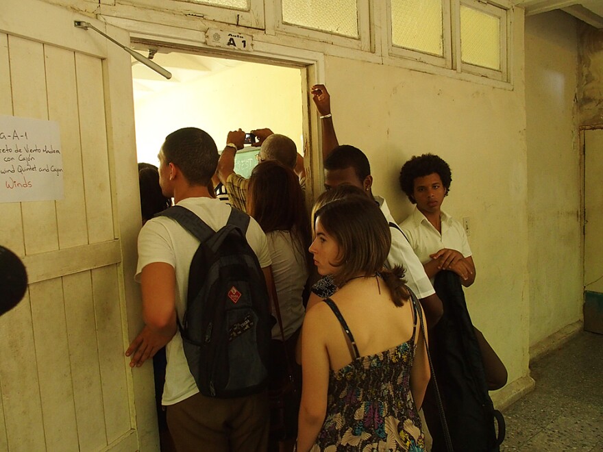 Students at the Escuela Nacional de Arte in Havana huddle around a doorway during a master class given by members of the visiting Minnesota Orchestra.