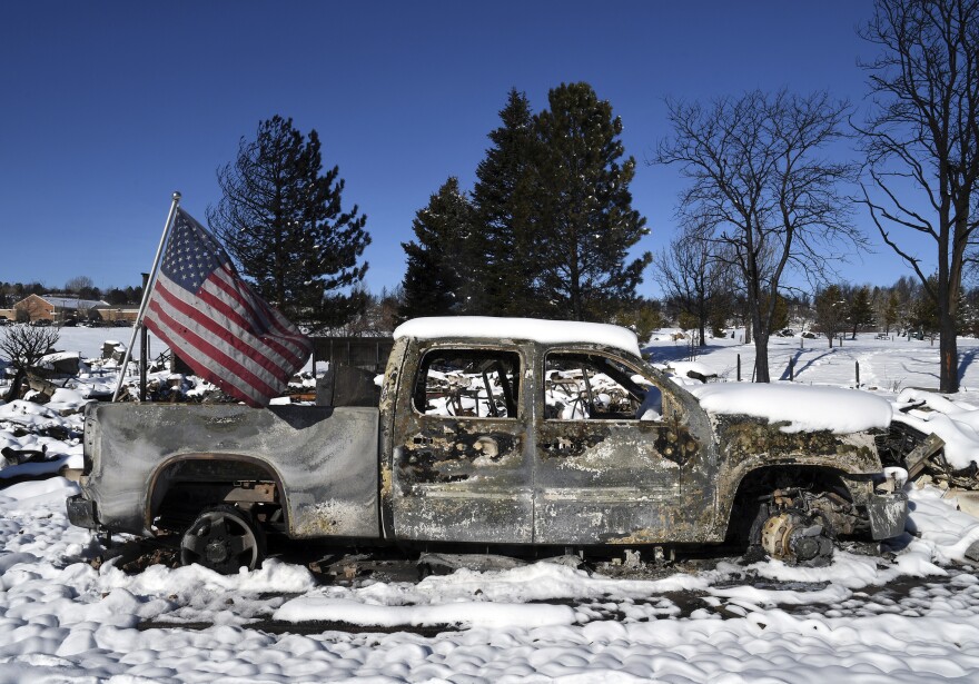 Here, a burned truck is pictured in a destroyed neighborhood in Louisville, Colo. Search teams looked for two missing people on Sunday in the snow-covered but still smoldering debris from a massive Colorado wildfire.