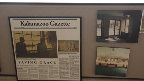 A newspaper clipping along with photos of what the church looked like before the renovations hang on the side of a desk. The tagline "Saving Grace" can be seen on the newspaper, which is framed along with the two photos.