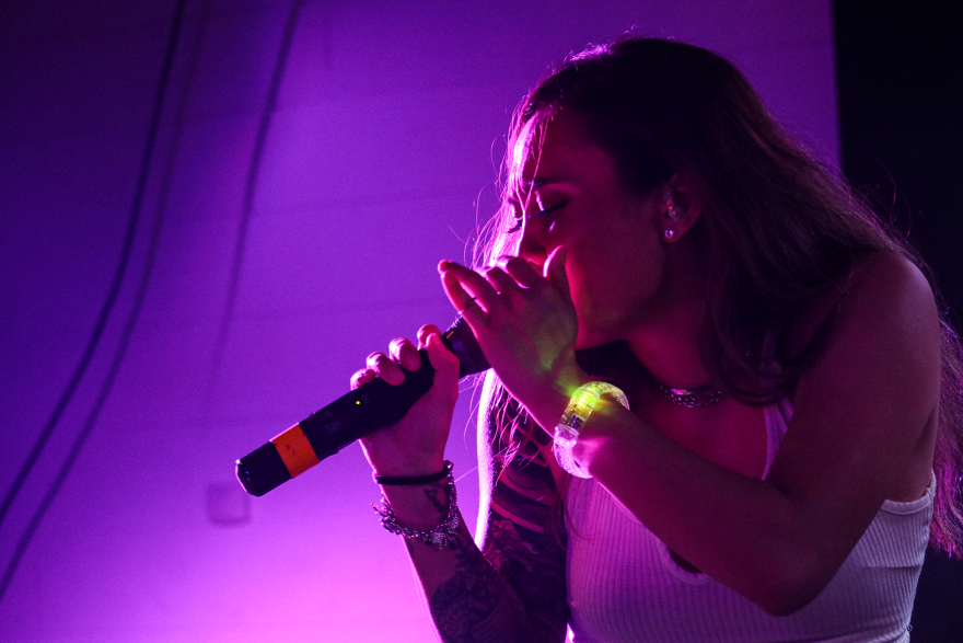 A Vietnamese-American woman spits into the microphone.