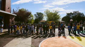 Students line up outside a playground.