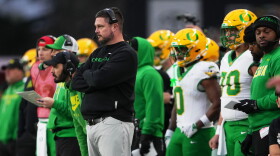 Oregon head coach Dan Lanning and players on the sidelines.