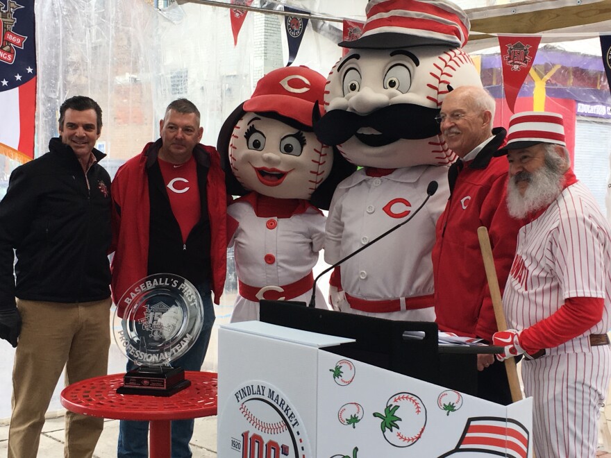 Findlay Market and the Reds looking ahead to the 100th parade and the 150th anniversary of professional baseball. From left: Reds President Phil Castellini, Parade Chair Neil Luken, mascots, and former radio personality Jim Scott.