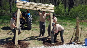 Indiana Division of Fish and Wildlife staff work to install a sign at the Wabash River Conservation Area.
