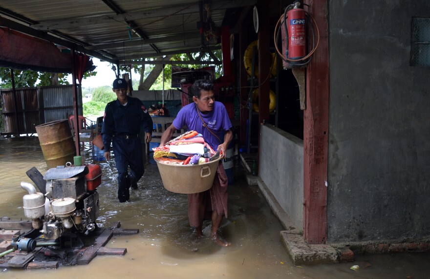 A resident evacuates with belongings from his home to escape the rising floodwaters in the Bago region in Myanmar on Wednesday.
