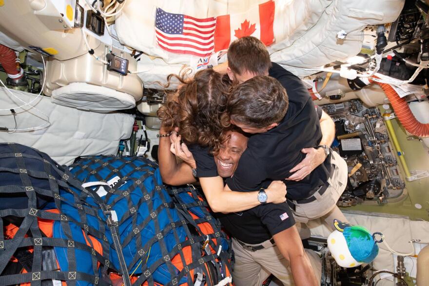 The Artemis II crew – (clockwise from left) Mission Specialist Christina Koch, Mission Specialist Jeremy Hansen, Commander Reid Wiseman, and Pilot Victor Glover – take time out for a group hug inside the Orion spacecraft on their way home. Following a swing around the far side of the Moon on April 6, 2026, the crew exited the lunar sphere of influence (the point at which the Moon's gravity has a stronger pull on Orion than the Earth's) on April 7, and are headed back to Earth for a splashdown in the Pacific Ocean on April 10. The crew was selected in April 2023, and have been training together for their mission for the past three years.