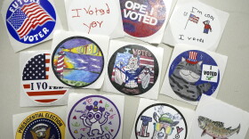 I voted stickers are displayed on a white table, each has a unique design.