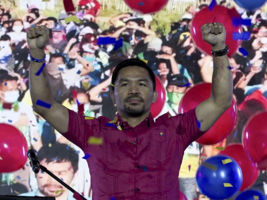 In this photo provided by the Manny Pacquiao MediaComms, Senator Manny Pacquiao raises his hands during a national convention of his PDP-Laban party in Quezon city, Philippines on Sunday Sept. 19, 2021. Philippine boxing icon and senator Manny Pacquiao says he will run for president in the 2022 elections.
