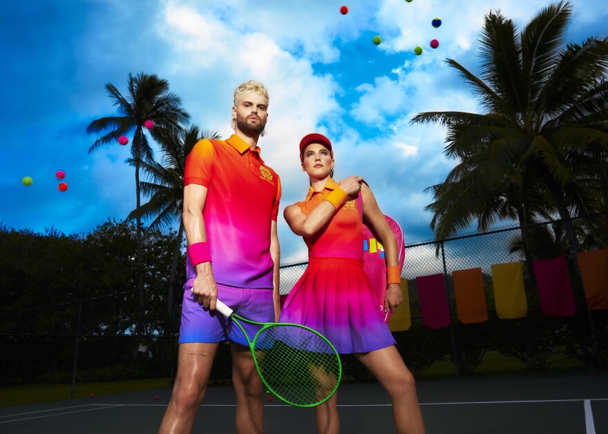 Sophie Hawley-Weld and Tucker Halpern. They are wearing rainbow-colored tennis clothes and standing outside.