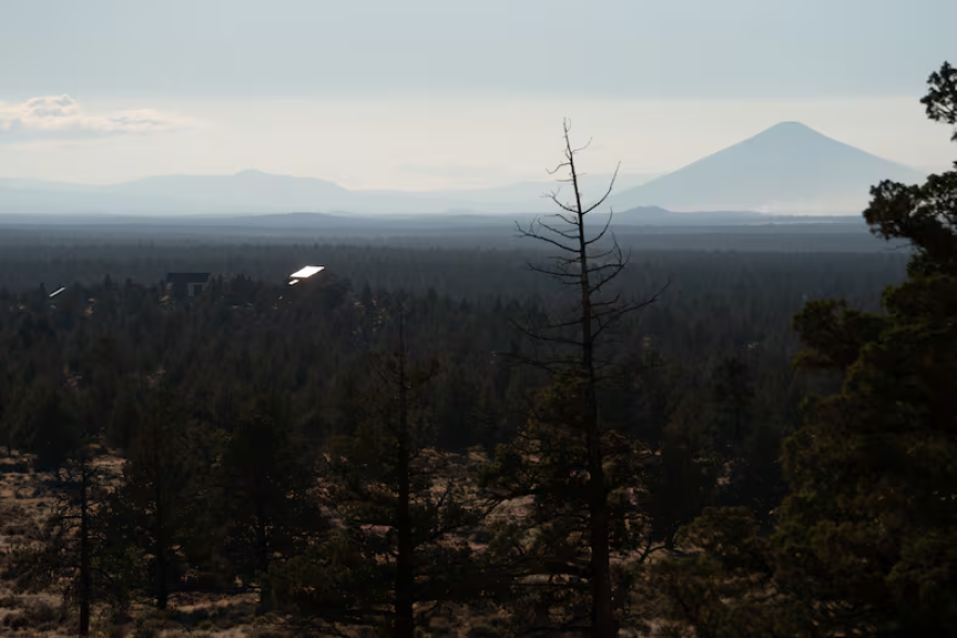 FILE - A house sits atop a hill in Redmond, Ore., as wildfire smoke from the Akawa Butte Fire, burning just north of Sisters, lingers in the air on July 24, 2026.