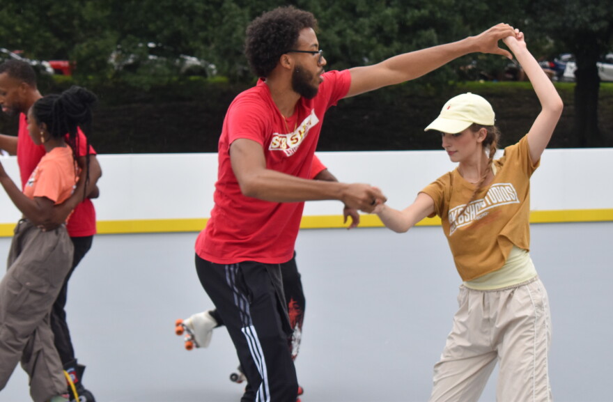 People on roller skates twirl each other.