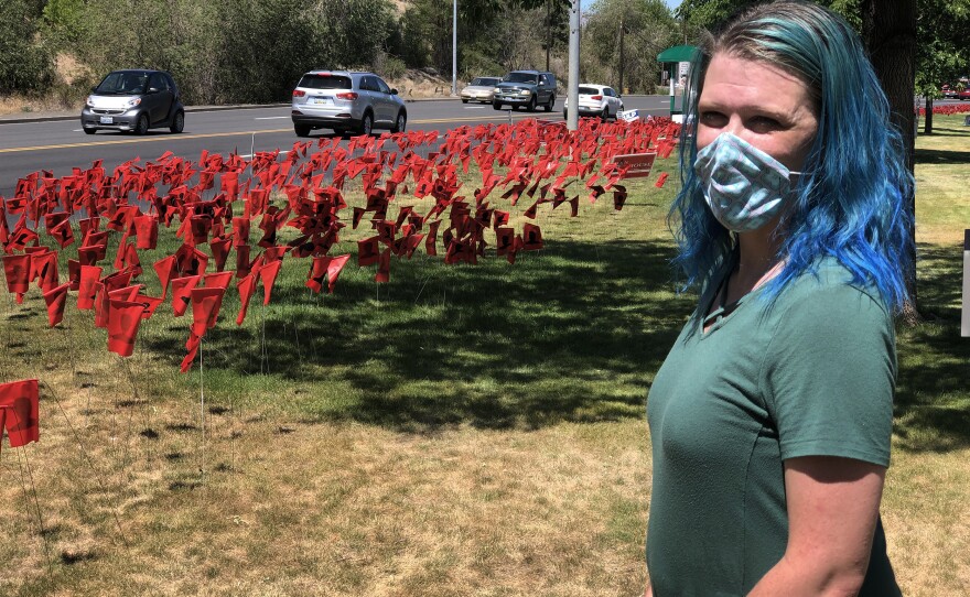 Leola Reeves has set up more than 8,000 red flags, each one with a black silhouette, to represent COVID-19 cases in Yakima County, Wash.