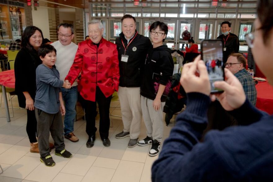 Dr. Henry Lee, Taiwanese American forensic scientist, center in red clothes, and Attorney General William Tong take photos with a family celebrating the Lunar New Year on Jan. 22, 2023. "You're gonna be an attorney general some day," Tong said to one of the children at the celebration.