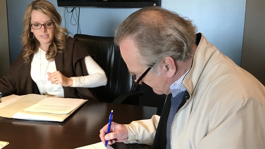 R.E. Olds Museum Executive Director Bill Adcock signs papers to complete building purchase photo