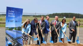 Dominion and elected officials throw dirt during a groundbreaking ceremony at Dulles International Airport. (Charlie Paullin / Virginia Mercury)