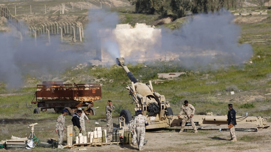 Iraqi security forces and Shiite fighters fire artillery during clashes with ISIS militants in Salahuddin province. The push to retake Tikrit is being aided by Iran, which is providing rockets and other support to Iraq.