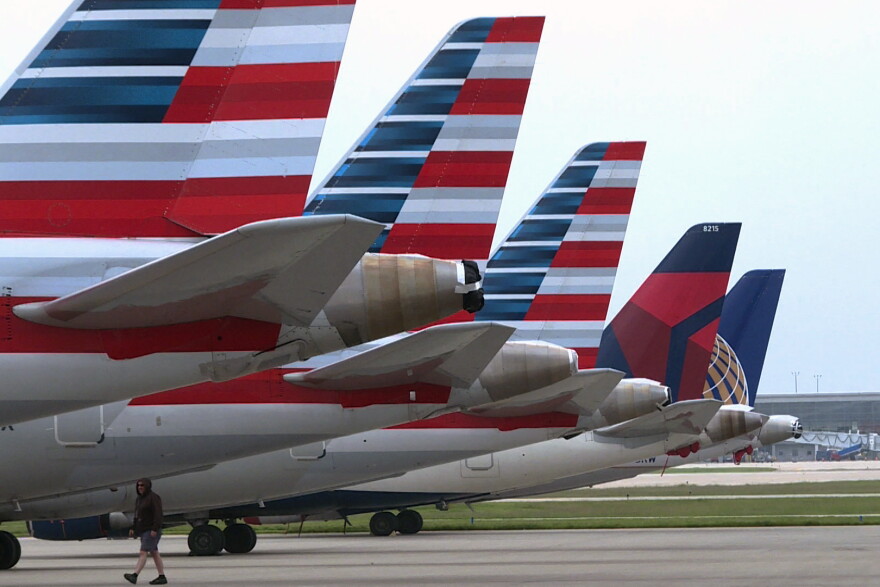 A worker on inspects multiple Republic Airways Embraer 170's on a previously vacant ramp at the Indianapolis International Airport.