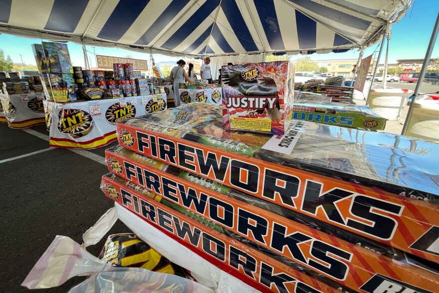 Shoppers grab some last-minute offerings from a pop-up fireworks stand in St. George, J