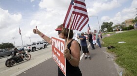 Pam Overton, of Sarasota, Fla., protests with others upset with players kneeling during the national anthem stand along a road leading to Raymond James Stadium before an NFL football game between the Tampa Bay Buccaneers and the New York Giants Sunday, Oct. 1, 2017, in Tampa, Fla. (Phelan M. Ebenhack/AP)