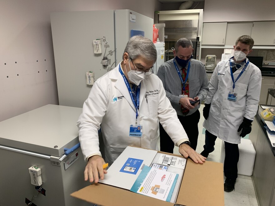 MetroHealth Pharmacy Services director Jay Kuhn opens the hospital's first shipment of COVID-19 vaccines Tuesday morning. Employees transferred the vials to a freezer for ultra-cold storage. [Anna Huntsman / ideastream]