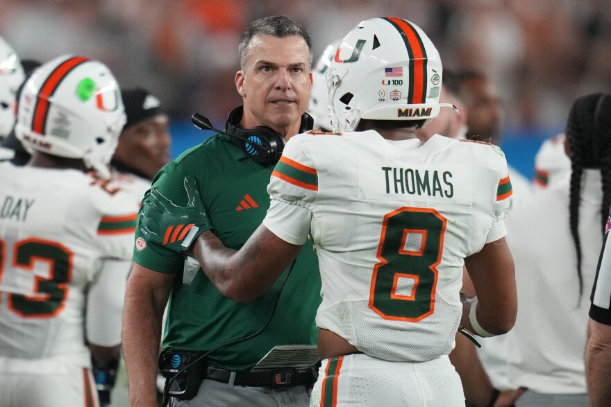 Miami head coach Mario Cristobal talks with defensive back Jakobe Thomas (8) during the second half of the Fiesta Bowl NCAA college football playoff semifinal game against Mississippi, Thursday, Jan. 8, 2026, in Glendale, Ariz. (AP Photo/Rick Scuteri)