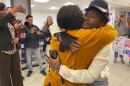Olivia Andre (right) embraces her mother, Carine Balenda Mbizi, at the Portland Jetport on Friday. Mbizi and her two younger children were released from ICE custody in March, and it’s unclear why Andre was not freed with them.