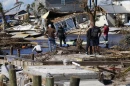 People stand on the destroyed bridge to Pine Island as they view the damage in the aftermath of Hurricane Ian in Matlacha, Fla., Sunday, Oct. 2, 2022.