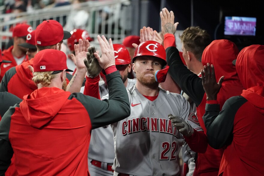 Cincinnati Reds' Brandon Drury, center, is greeted in the dugout after hitting a three-run home run against the Atlanta Braves during the sixth inning of a baseball game Thursday, April 7, 2022, in Atlanta. 