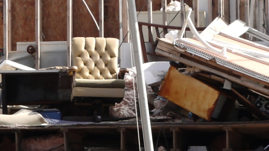 What remains of this home is a lonely, cream colored chair amid skeleton walls. 