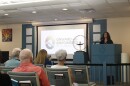 a woman standing at a podium speaks to an audience at a church