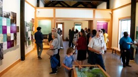 Visitors look at a timeline of the Great Dismal Swamp's history at the newly opened Historical Village.