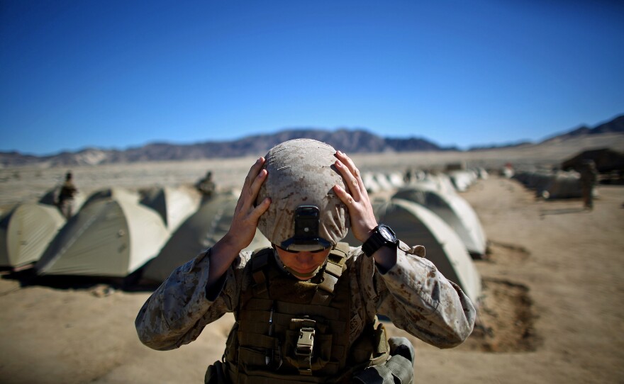 Sgt. Kelly Brown adjusts her helmet before a weapons check.