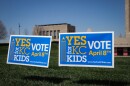 Two blue signs sit on the lawn of the World War 1 Museum and Memorial