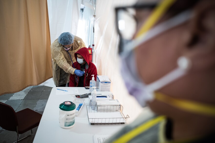 A doctor examines Juan Vasquez as part of a COVID-19 check inside a testing tent outside the emergency department at St. Barnabas Hospital in New York City last week.