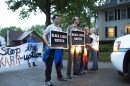 Activists continue to demonstrate against city attorney Stephanie Karr as a police vehicle idles in front of them near Karr's home on Wesley Avenue Monday evening.