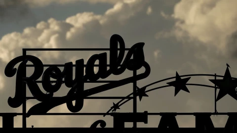Storm clouds pass in the distance before the start of a rain-delayed Kansas City Royals game.