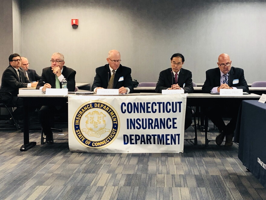 Insurance officials attend a public hearing on proposed rate hikes in 2019.