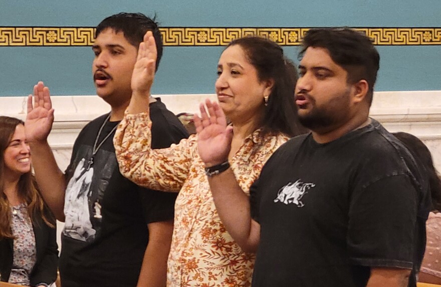 A family swears allegiance to the United States during their naturalization ceremony